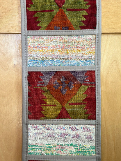 Decorative, handmade Turkish rug wall organizer with vibrant stripe designs and 3 storage pockets. Upcycled vintage textile art by High Pile Designs. Featuring wrapped gifts.