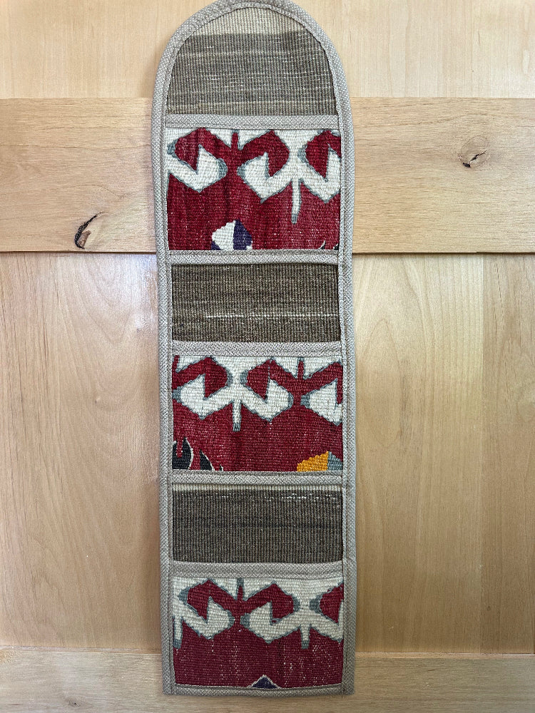 Decorative, handmade Turkish rug wall organizer with vibrant stripe designs and 3 storage pockets. Upcycled vintage textile art by High Pile Designs. 