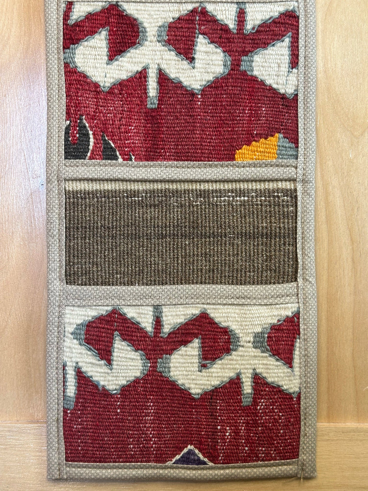 Decorative, handmade Turkish rug wall organizer with vibrant stripe designs and 3 storage pockets. Upcycled vintage textile art by High Pile Designs. 