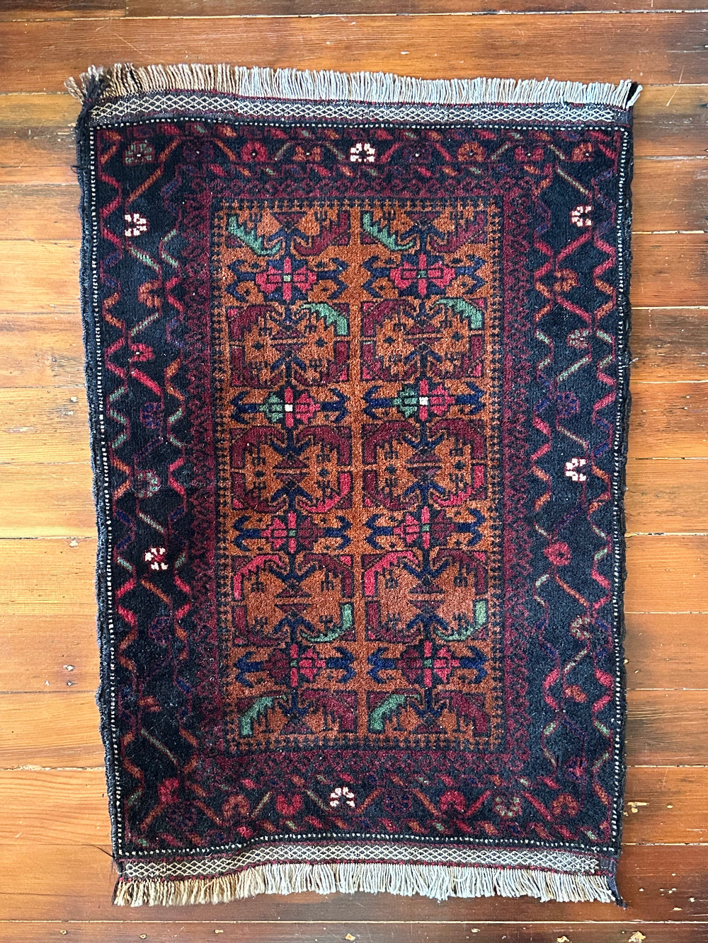 Decorative rug with intricate patterns on a wooden floor