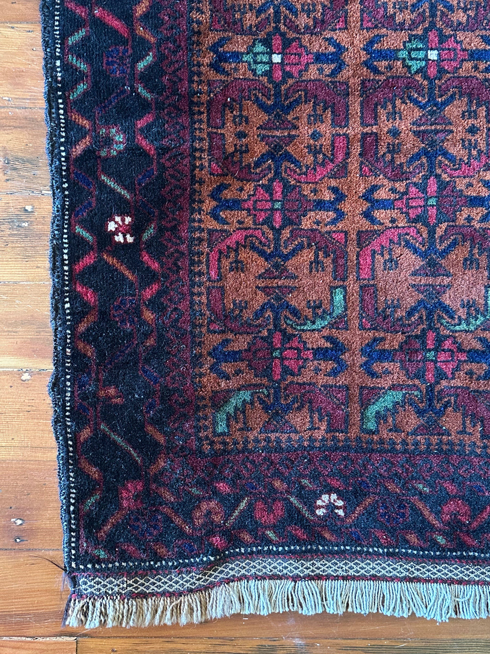 Decorative rug with intricate patterns on a wooden floor