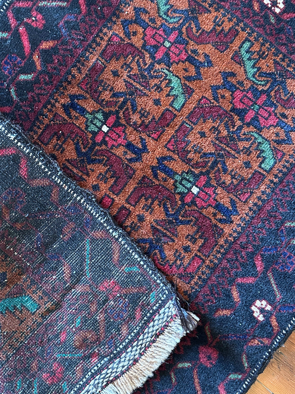 Decorative rug with intricate patterns on a wooden floor