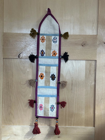 3 pocket hanging wall organizer made from Turkish rug fragments featuring embroidered floral pockets