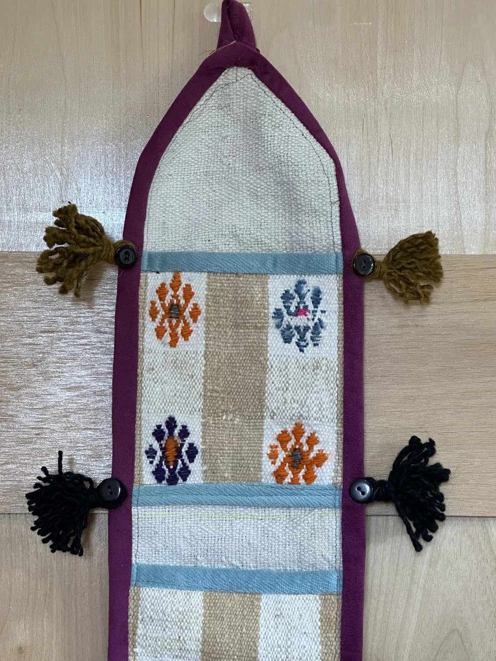 3 pocket hanging wall organizer made from Turkish rug fragments featuring embroidered floral pockets