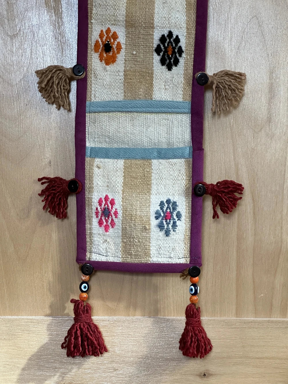 3 pocket hanging wall organizer made from Turkish rug fragments featuring embroidered floral pockets