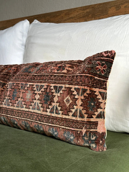 12 by 36 inch Turkish lumbar pillow insert featuring a velvet soft low pile and a maroon and navy geometric design throughout