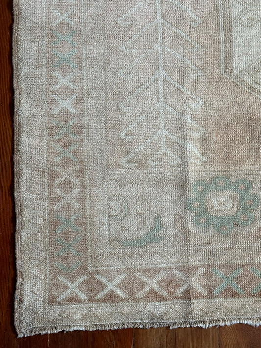 5 by 8 neutral Turkish are rug featuring double border and muted brown tones with pops of blue