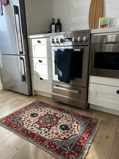 Handknotted mini Kazak rug with intricate geometric patterns, rich red and deep blue hues, and a durable low-pile wool construction. Made to order in custom sizes, perfect for adding a bold, traditional touch to vintage, classic, or eclectic home décor.