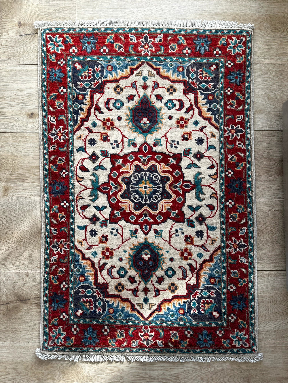 Handknotted mini Kazak rug with intricate geometric patterns, rich red and deep blue hues, and a durable low-pile wool construction. Made to order in custom sizes, perfect for adding a bold, traditional touch to vintage, classic, or eclectic home décor.