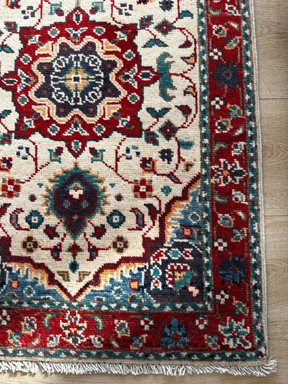 Handknotted two by three foot mini Kazak rug with intricate geometric patterns, rich red and deep blue hues, and a durable low-pile wool construction. Made to order in custom sizes, perfect for adding a bold, traditional touch to vintage, classic, or eclectic home décor.