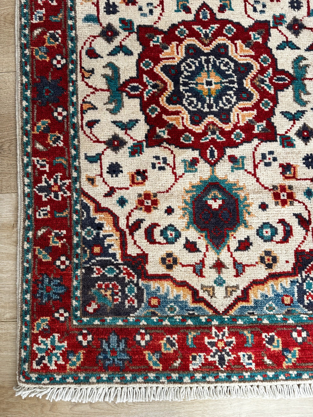 Handknotted two by three foot mini Kazak rug with intricate geometric patterns, rich red and deep blue hues, and a durable low-pile wool construction. Made to order in custom sizes, perfect for adding a bold, traditional touch to vintage, classic, or eclectic home décor.