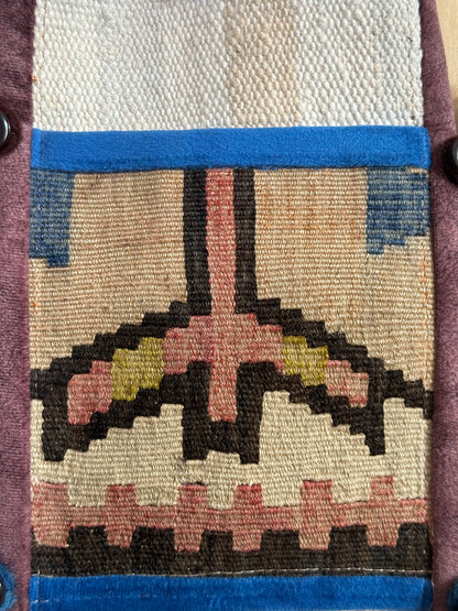 Handmade Turkish wall hanging with vintage rug patterns, featuring colorful tassels, evil eye beads, and geometric designs on a wood panel background. Unique bohemian decor made from authentic Turkish rug fragments, perfect for home styling.