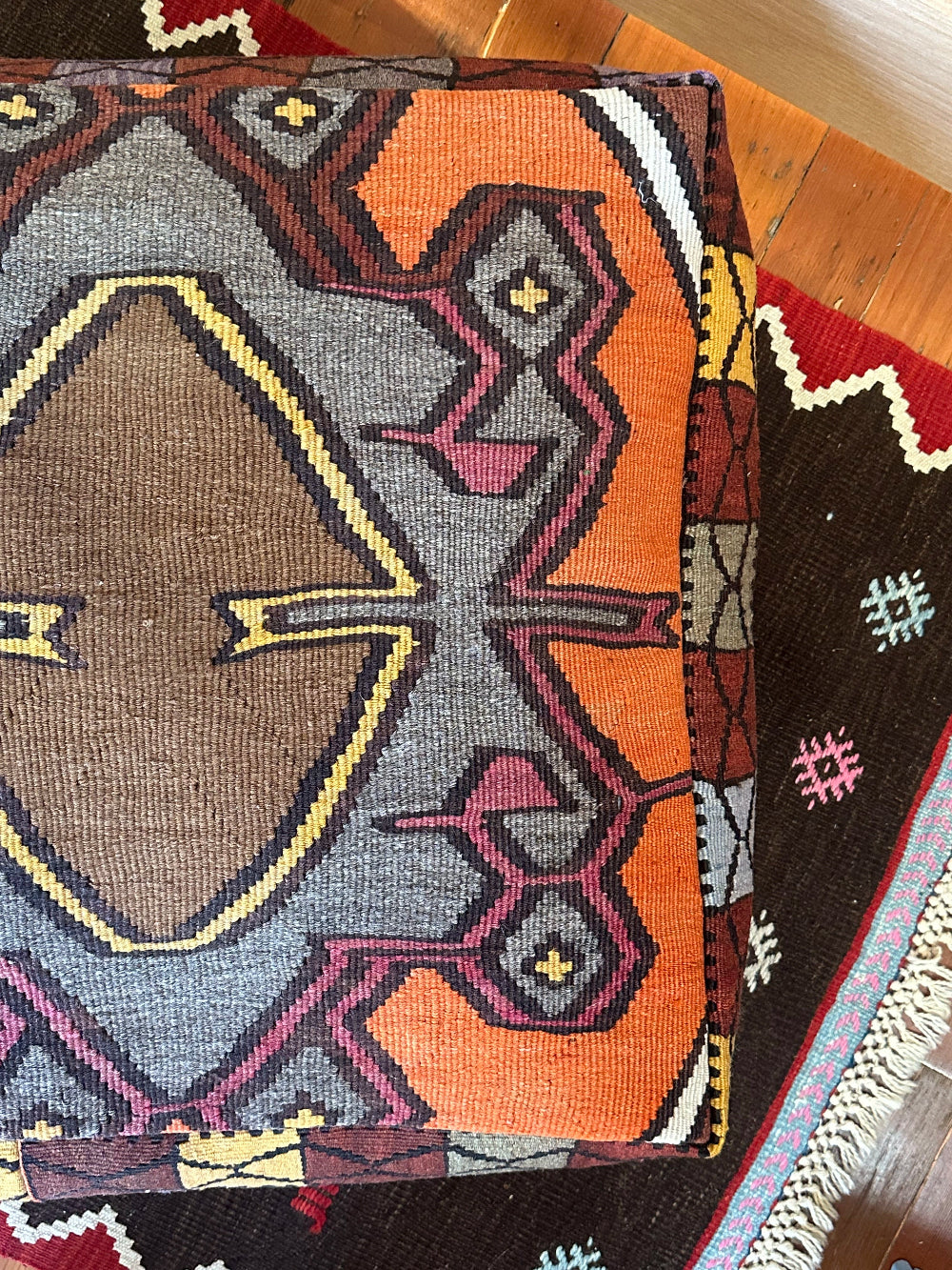 Handmade vintage Turkish rug pouf with colorful tones and a large central medallion, up-cycled from authentic wool Kilim rugs. Perfect as a unique bohemian floor cushion, ottoman, or accent seating for living rooms, bedrooms, or cozy spaces. Ethically crafted by artisans in Turkey.