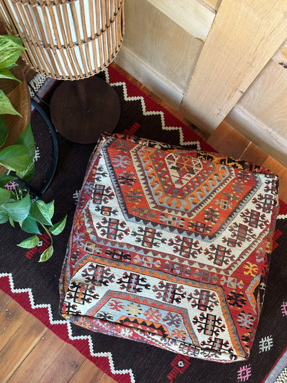 Handmade vintage Turkish rug pouf with red and orange tones, up-cycled from authentic wool Kilim rugs. Perfect as a unique bohemian floor cushion, ottoman, or accent seating for living rooms, bedrooms, or cozy spaces. Ethically crafted by artisans in Turkey.