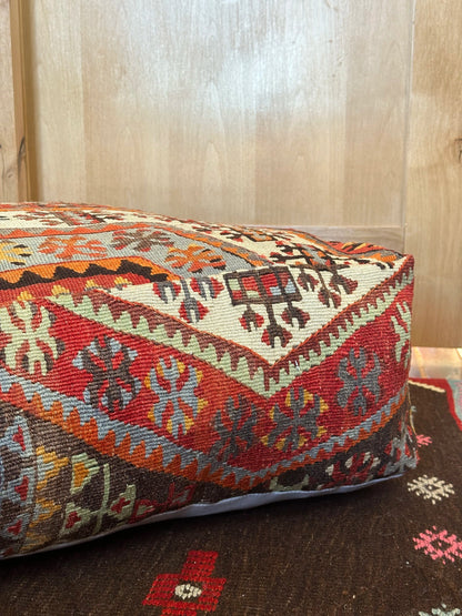 Handmade vintage Turkish rug pouf with red and orange tones, up-cycled from authentic wool Kilim rugs. Perfect as a unique bohemian floor cushion, ottoman, or accent seating for living rooms, bedrooms, or cozy spaces. Ethically crafted by artisans in Turkey.