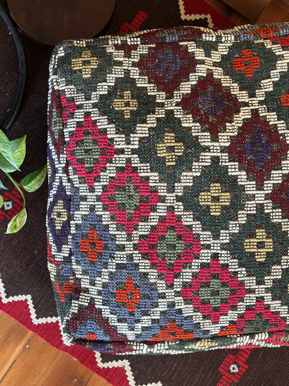 Handmade vintage Turkish rug pouf with colorful tones, up-cycled from authentic wool Kilim rugs. Perfect as a unique bohemian floor cushion, ottoman, or accent seating for living rooms, bedrooms, or cozy spaces. Ethically crafted by artisans in Turkey.