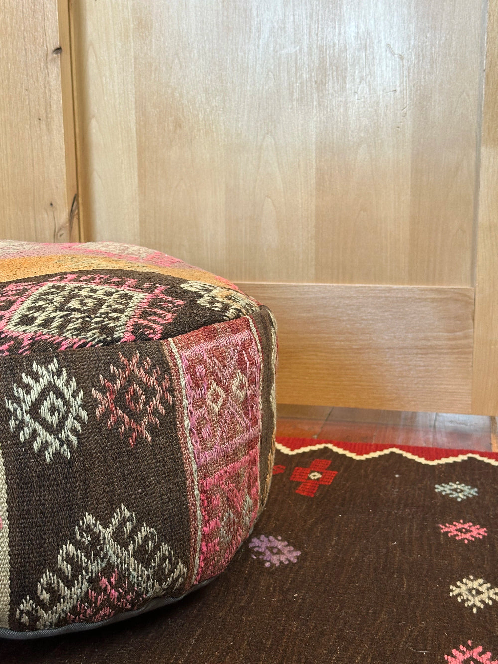 Handmade vintage Turkish rug pouf with pink and orange sunset tones, up-cycled from authentic wool Kilim rugs. Perfect as a unique bohemian floor cushion, ottoman, or accent seating for living rooms, bedrooms, or cozy spaces. Ethically crafted by artisans in Turkey.