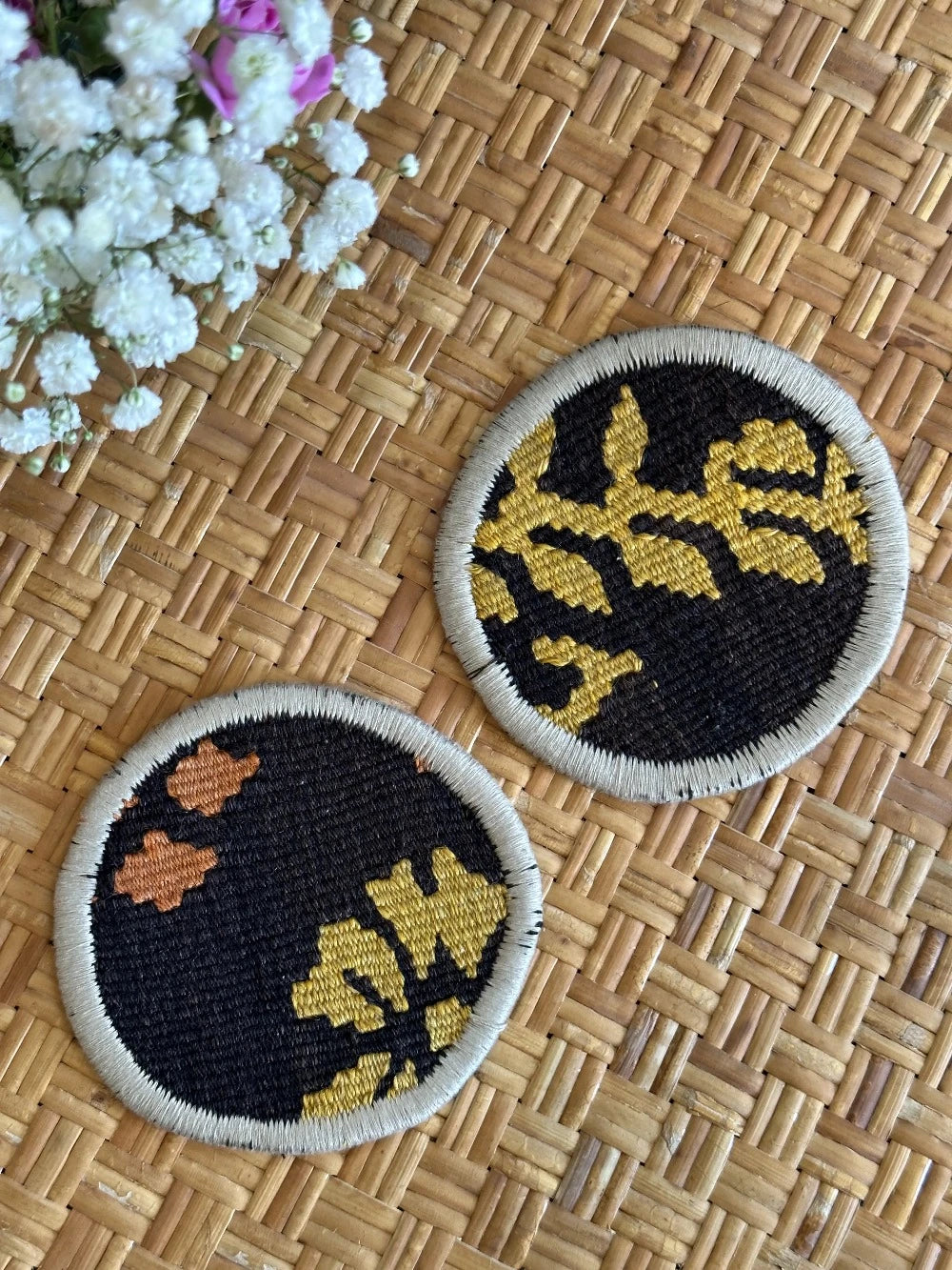 Set of 2 Turkish fabric coasters made from recycled rug and pillow fabric, featuring yellow and orange floral pattern on black background