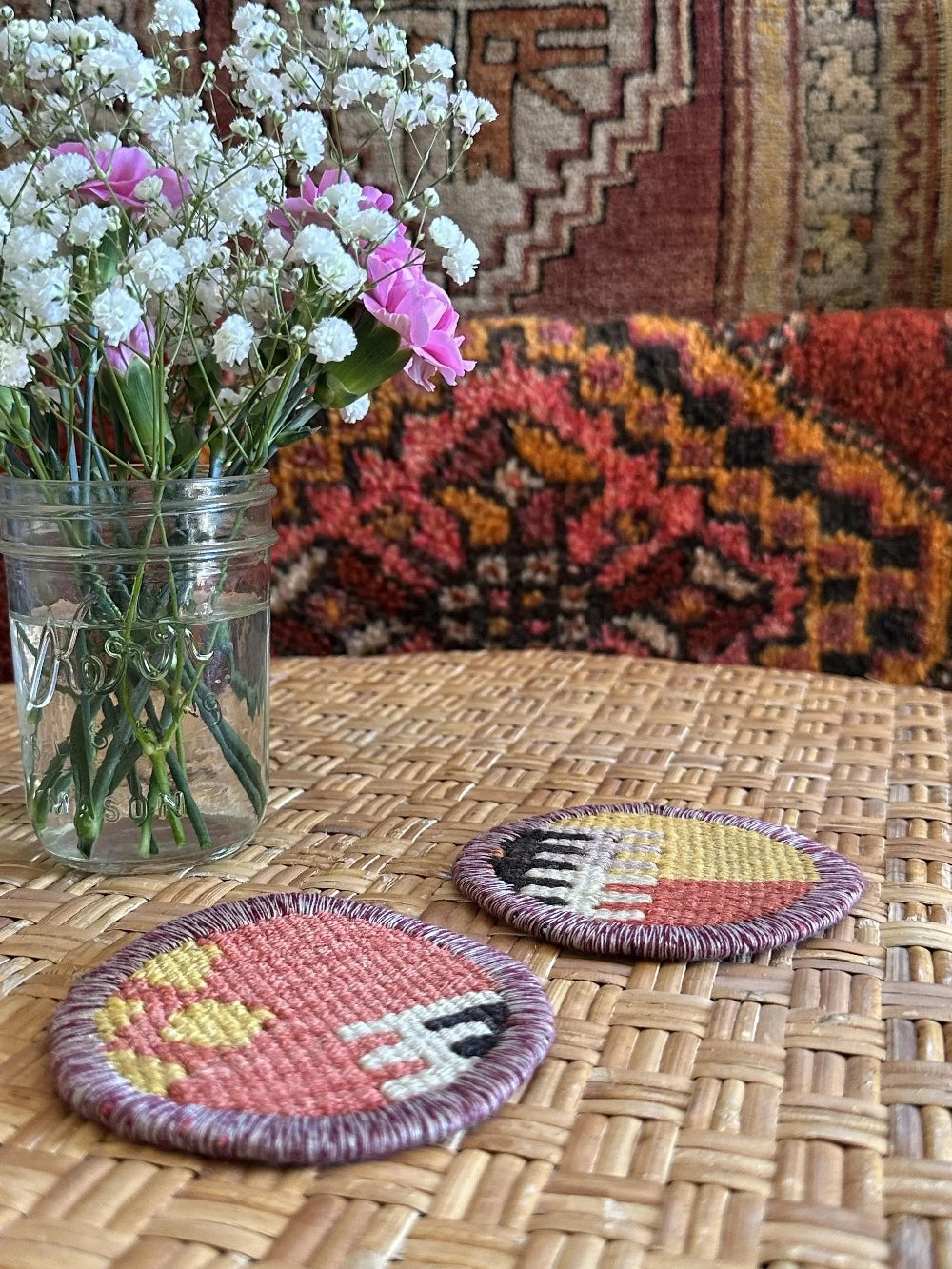 Set of 2 Turkish rug coasters made from old rugs and pillows, measuring 3.75 inches in diameter and featuring a colorful geometric pattern