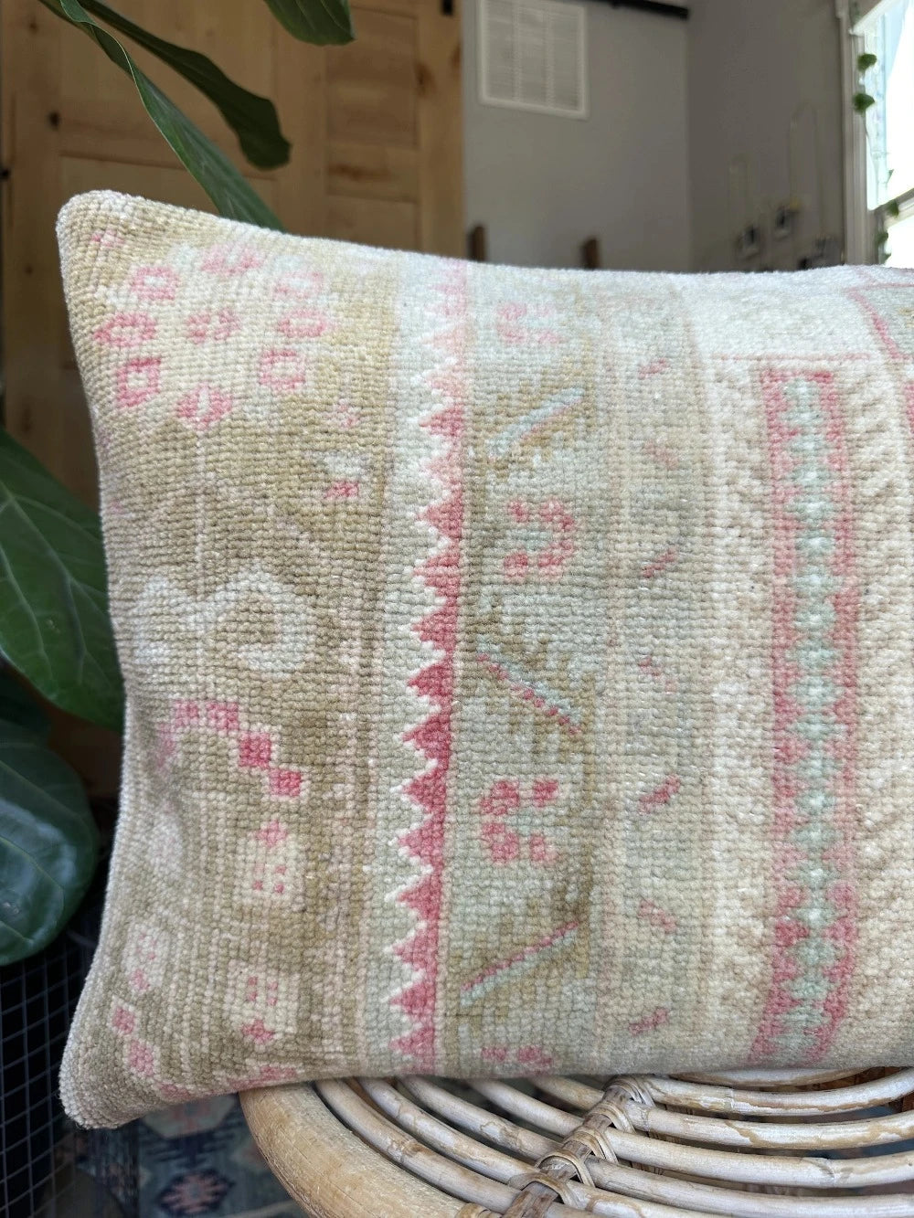 16 by 24 neutral Turkish Lumbar pillow featuring pops of pink and geometric floral pattern throughout