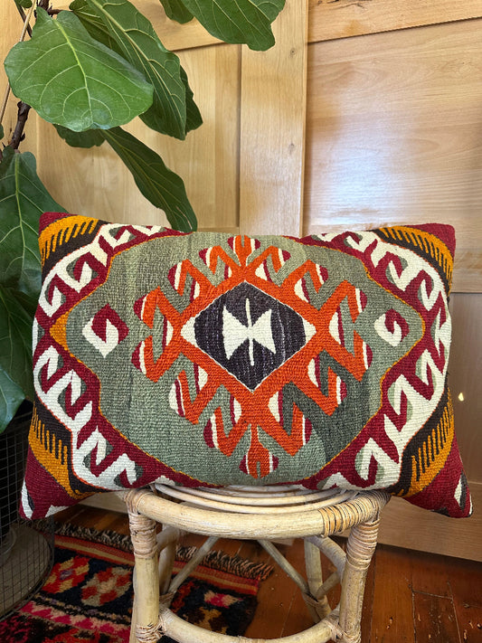 16 by 24 Decorative pillow with geometric pattern on a wooden stool indoors