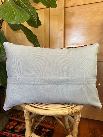16 by 24 Decorative pillow with geometric pattern on a wooden stool indoors