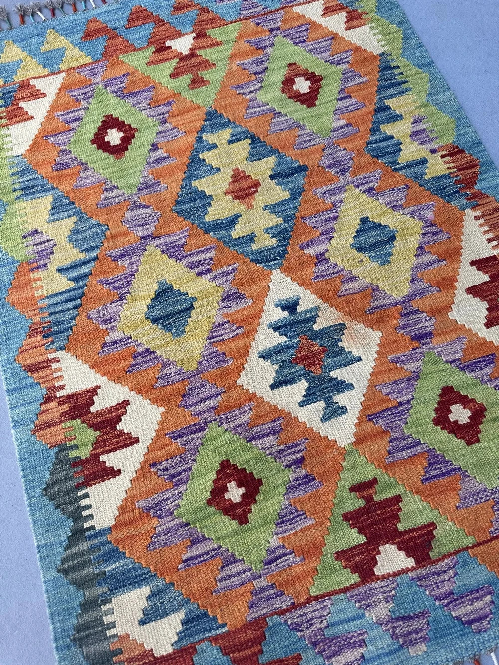 3.5 foot by 2.5 foot small kilim mini rug featuring a multicolored rainbow diamond pattern