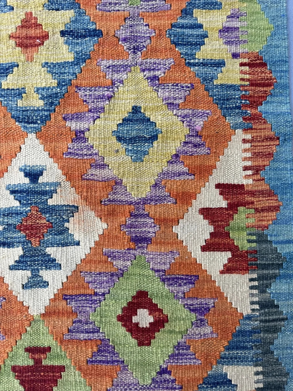 3.5 foot by 2.5 foot small kilim mini rug featuring a multicolored rainbow diamond pattern