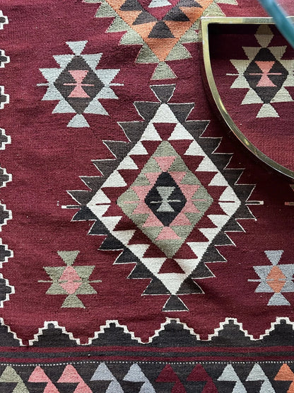 8 by 5 foot large red Turkish kilim area rug featuring large diamond medallions in the center and multiple striped borders around the outside