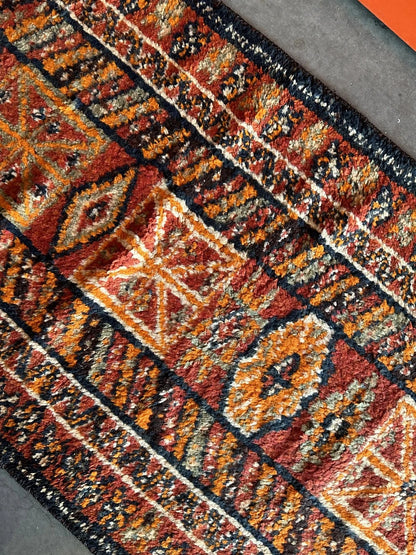 11 foot by 3 foot Turkish high pile Herki runner, featuring a black, red and orange geometric pattern throughout