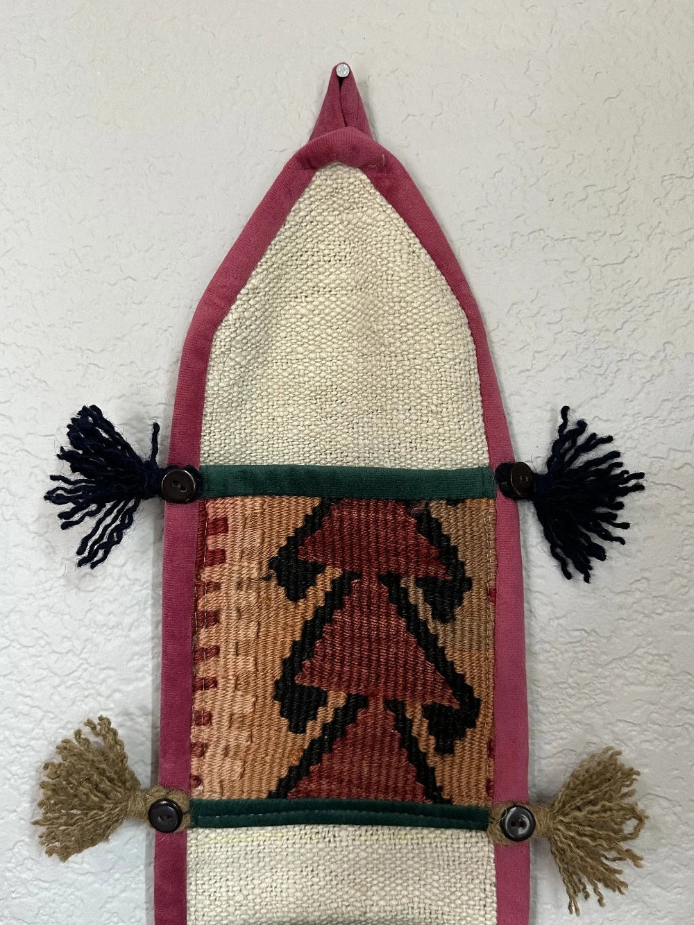 multi-colored three pocket wall organizer made from scraps of colorful Turkish kilim rugs with yarn tassels at each end