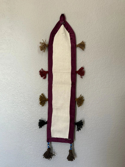 multi-colored three pocket wall organizer made from scraps of colorful Turkish kilim rugs with yarn tassels at each end