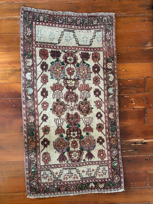 Vintage Turkish wool rug with a floral tree of life design in burgundy, green, and ivory tones, featuring a detailed border of small floral motifs.
