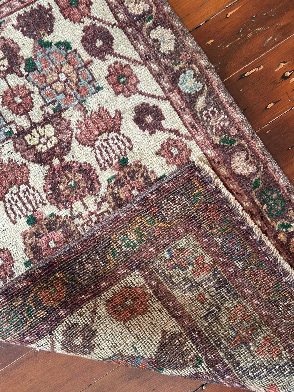 Vintage Turkish wool rug with a floral tree of life design in burgundy, green, and ivory tones, featuring a detailed border of small floral motifs.