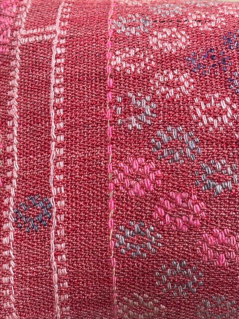 Rectangular red vintage Turkish kilim pillow with small repeating geometric patterns, made from handwoven wool.
