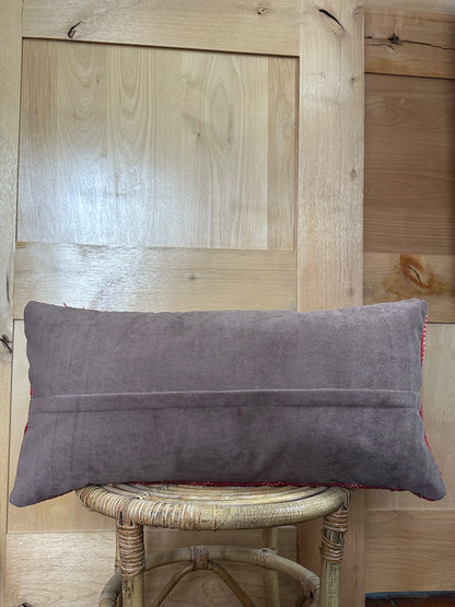Rectangular red vintage Turkish kilim pillow with small repeating geometric patterns, made from handwoven wool.