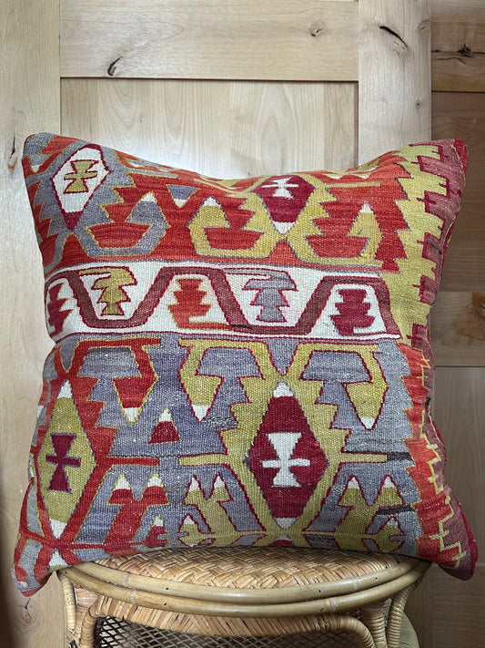 Large 26x26 kilim pillow sustainably handmade from vintage Turkish wool rugs. Features bold tribal motifs in olive, terracotta, and ivory tones.