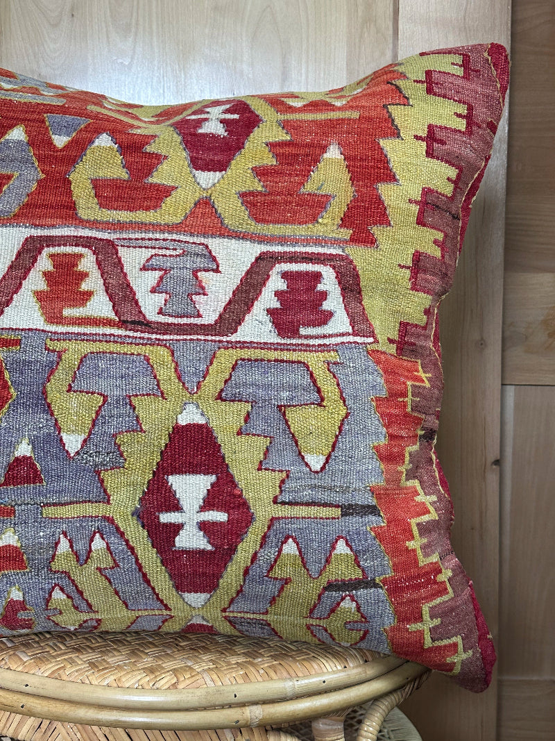 Large 26x26 kilim pillow sustainably handmade from vintage Turkish wool rugs. Features bold tribal motifs in olive, terracotta, and ivory tones.