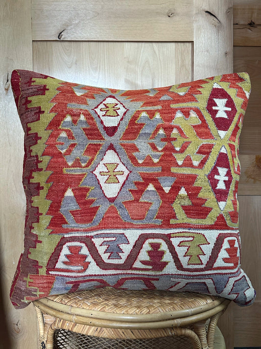 Large 26x26 kilim pillow sustainably handmade from vintage Turkish wool rugs. Features bold tribal motifs in olive, terracotta, and ivory tones.