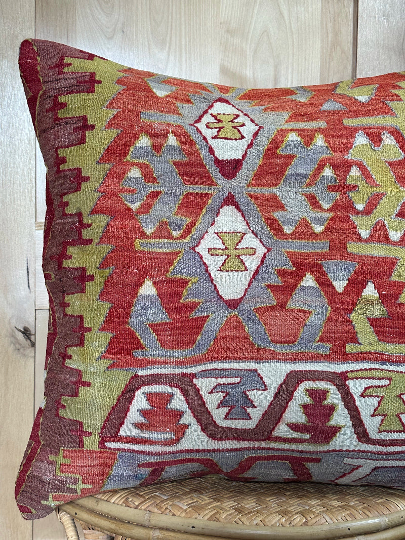Large 26x26 kilim pillow sustainably handmade from vintage Turkish wool rugs. Features bold tribal motifs in olive, terracotta, and ivory tones.