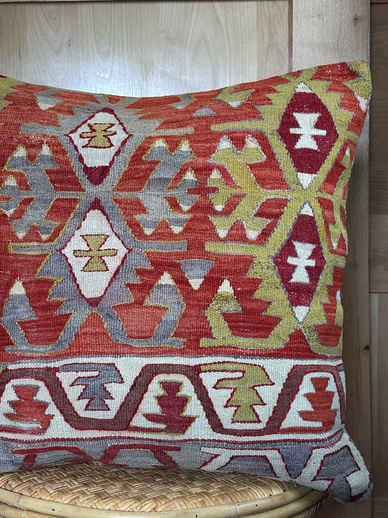 Large 26x26 kilim pillow sustainably handmade from vintage Turkish wool rugs. Features bold tribal motifs in olive, terracotta, and ivory tones.