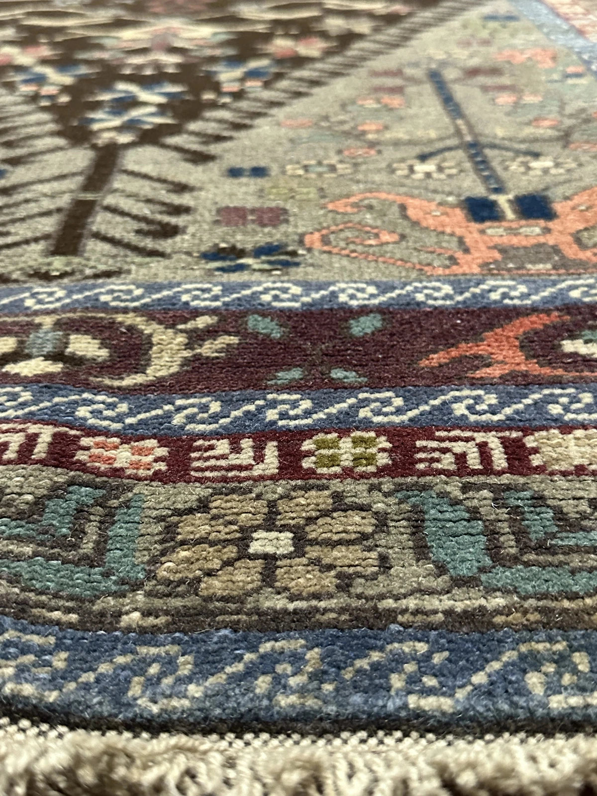 Large vintage Turkish rug featuring floral and geometric designs with hues of navy, robin eggs blue, olive, mauve and taupe.