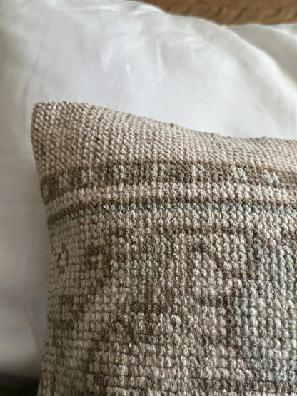 12 by 36 neutral handmade Turkish lumbar pillow featuring brown and sand coloring and a geometric floral pattern