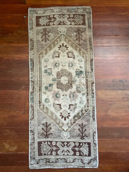 Neutral Turkish area rug featuring soft brown and tan tones with pops of blue and geometric designs