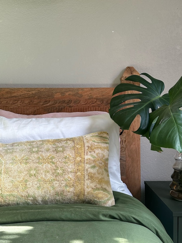 Neutral Turkish lumbar pillow featuring pops of chartreuse and gold coloring with floral border design