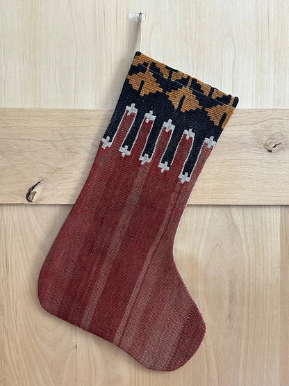 handmade Turkish Christmas stocking featuring a solid red body and a black and orange geometric top