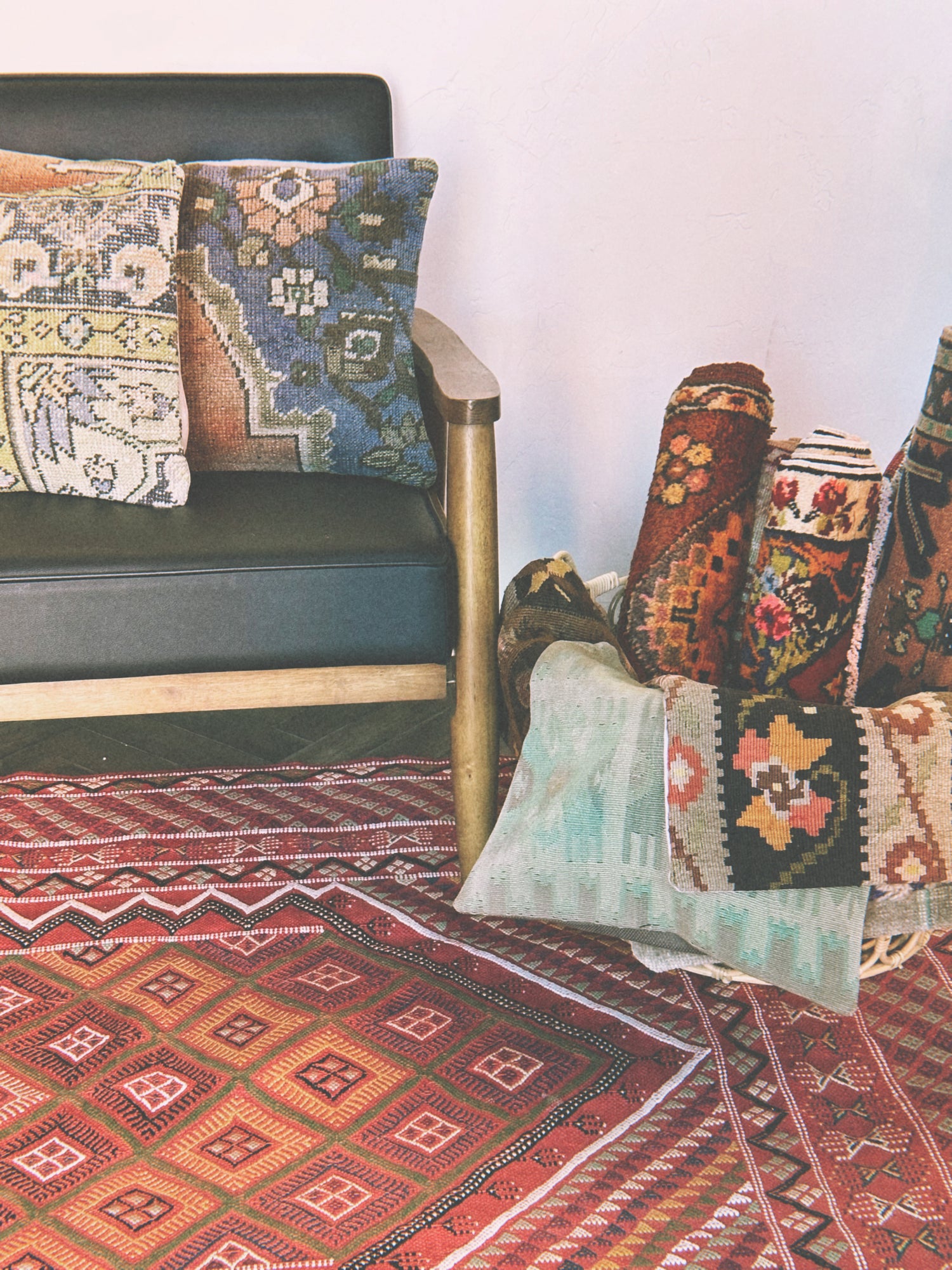 assortment of colorful turkish rugs and pillows featuring geometric and floral embroidered designs