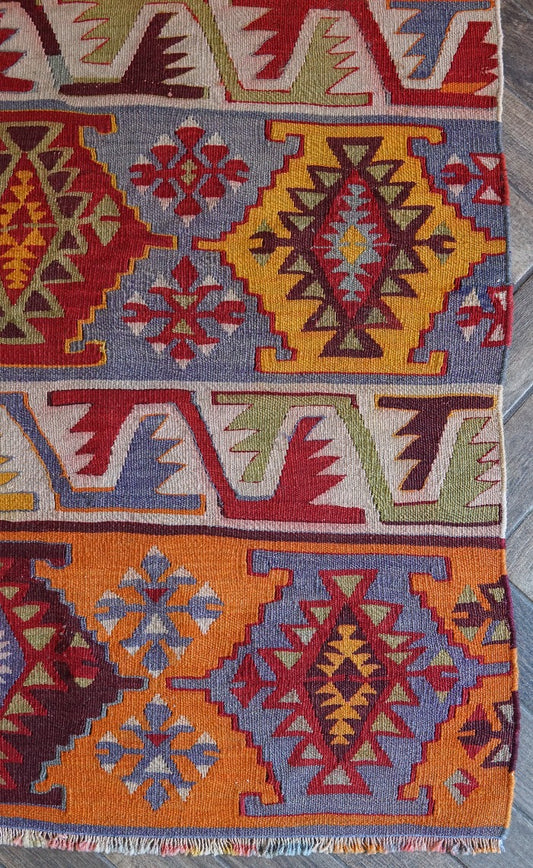 6 by 2.5 small colorful Turkish kilim runner featuring multicolored stripes around 12 inches wide and many different geometric patterns throughout
