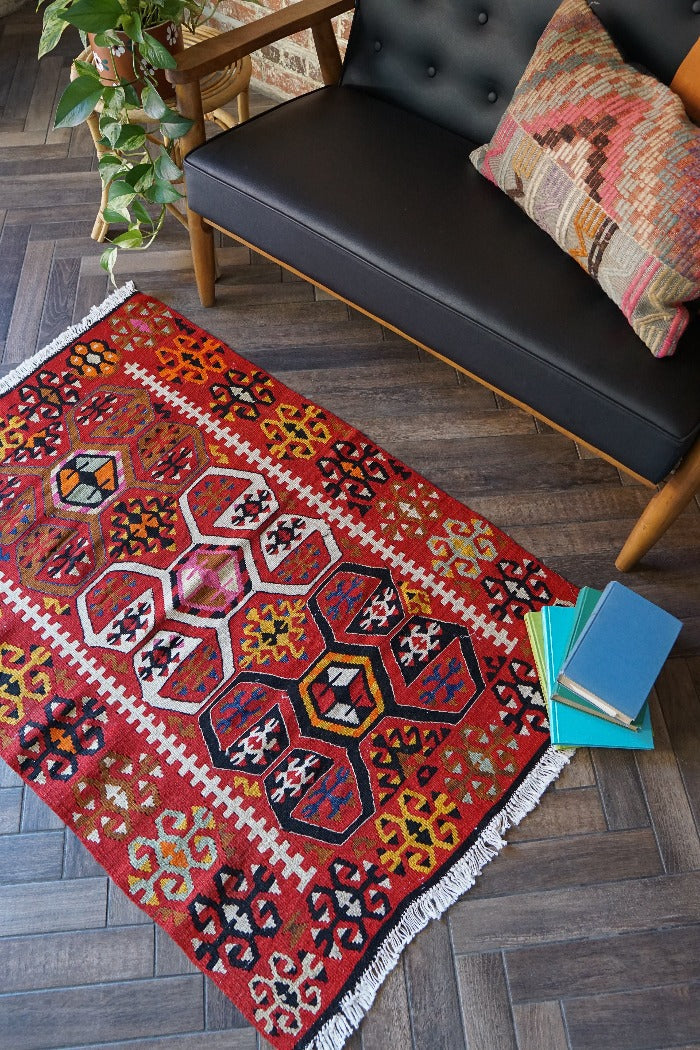 5 by 3 bright red Turkish area rug featuring floral and geometric border with pops of green, yellow, orange, perfect condition