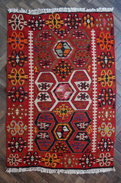 5 by 3 bright red Turkish area rug featuring floral and geometric border with pops of green, yellow, orange, perfect condition